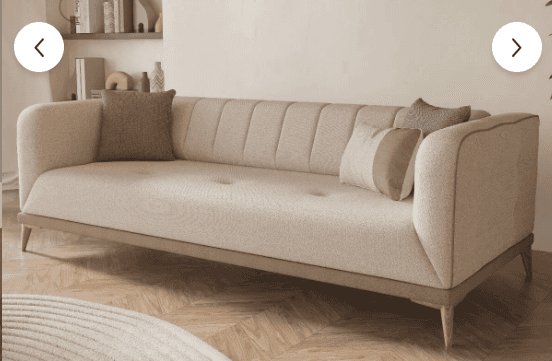 A contemporary three-seater sofa upholstered in a light beige fabric, featuring vertical channel tuf… — 3D model