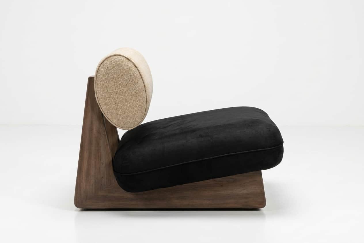 A modern, low-profile lounge chair featuring a distinctive solid wood base. The base is dark-toned w… — 3D model