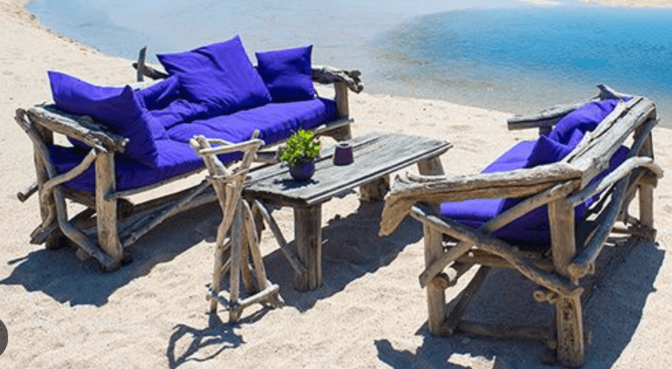 A rustic outdoor patio furniture set featuring a three-seater sofa, a single armchair, and a rectang… — 3D model