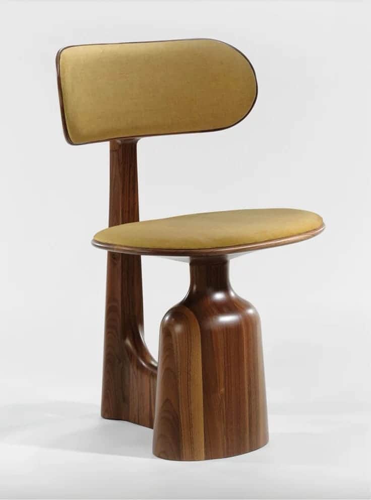 A uniquely designed chair with a sculpted wooden base and a cushioned seat and backrest. The base fe… — free FBX 3D model