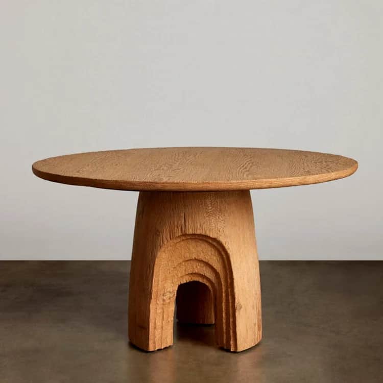 A round wooden coffee table featuring a thick, sculptural pedestal base with deeply carved, layered… — 3D model