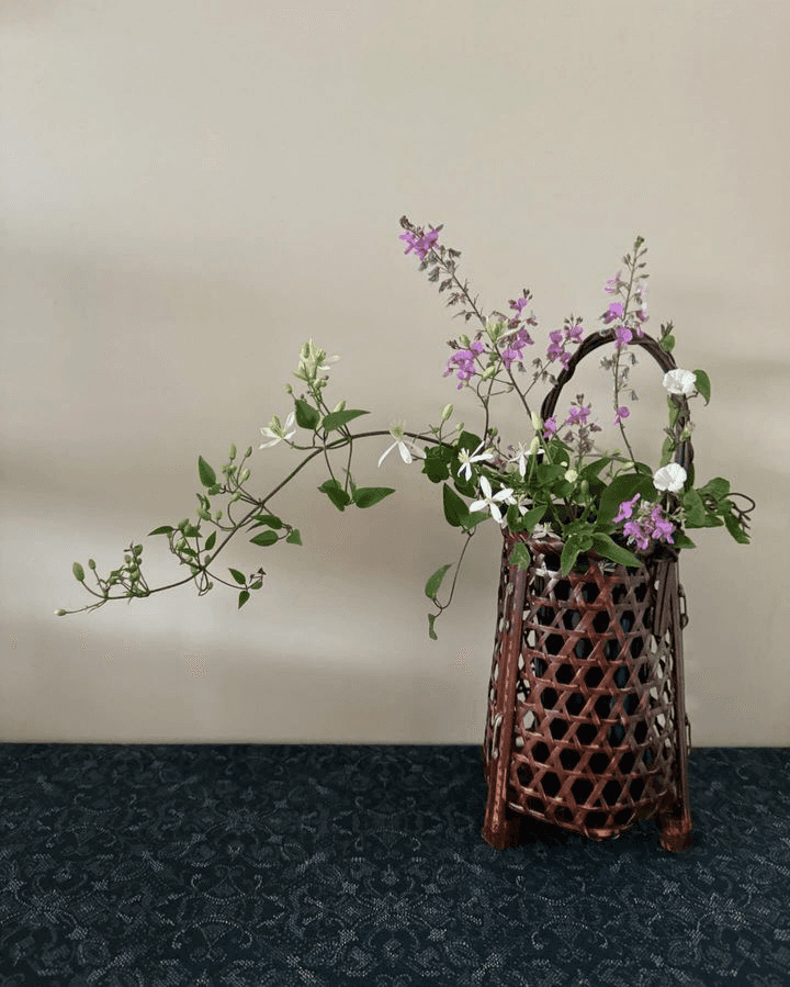 A traditional Japanese ikebana vase, meticulously crafted from dark, lacquered woven bamboo in a hex… — 3D model