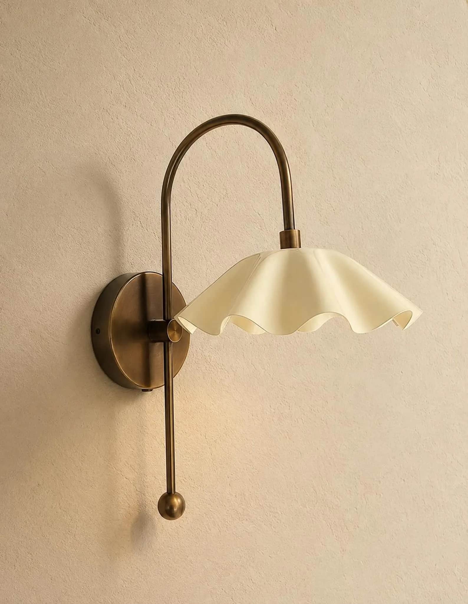 An aged brass wall sconce featuring a curved gooseneck arm and a distinctive ruffled, opaque cream-c… — 3D model