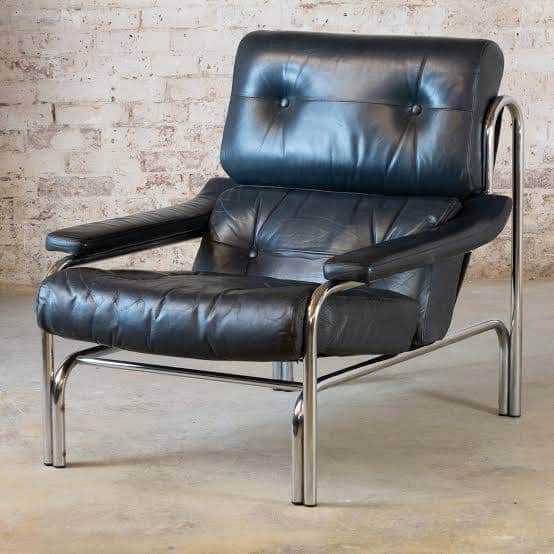 A modernist lounge chair featuring a polished chrome tubular frame and black tufted leather upholste… — 3D model