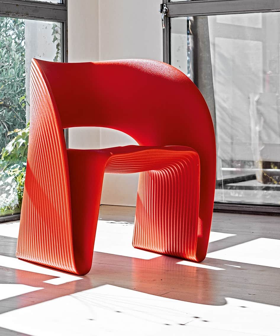 A vibrant red, contemporary armless chair featuring a sculptural, monobloc design. The surface has a… — 3D model
