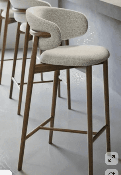 A modern bar stool featuring a light-colored, textured upholstered seat and a curved backrest that i… — 3D model