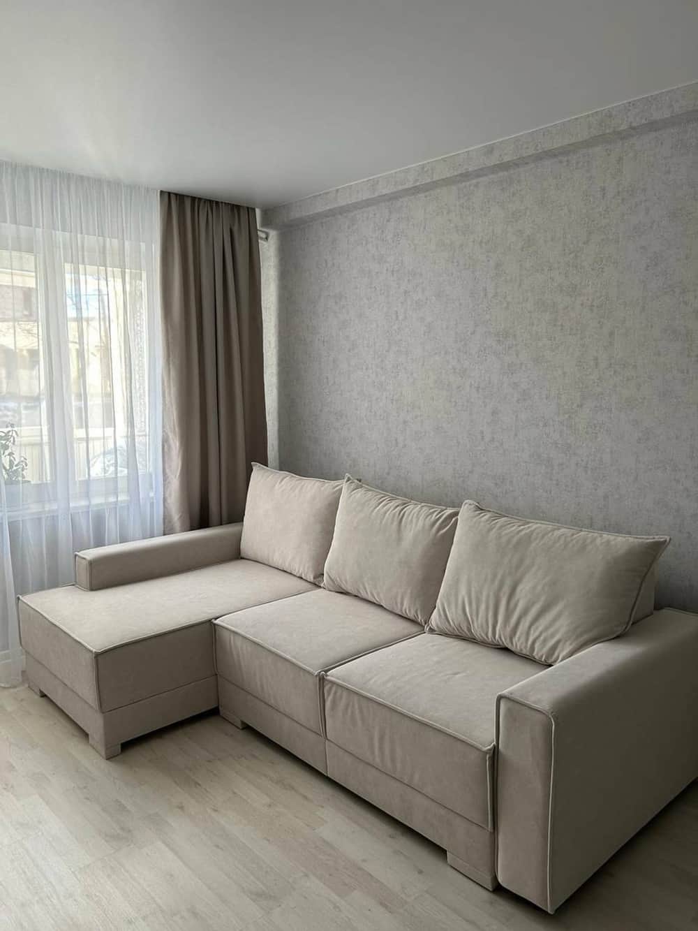 An L-shaped sectional sofa upholstered in a light beige fabric, featuring an integrated left-hand fa… — 3D model