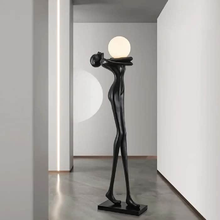 A contemporary floor lamp featuring a sculptural, stylized humanoid figure in black, holding a spher… — 3D model