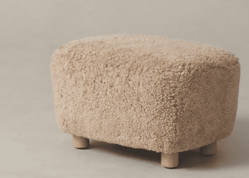 A rectangular ottoman with rounded edges, covered in a textured, fluffy, off-white material resembli… — 3D model