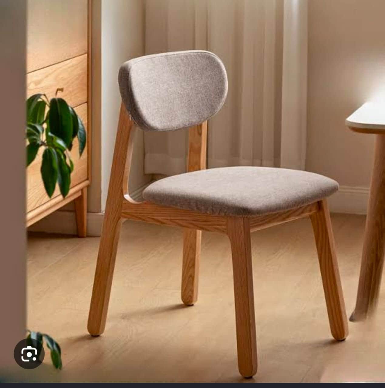 A modern armless dining chair featuring a light-toned wooden frame and upholstered seat and back in… — 3D model