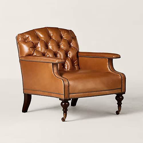 A traditional club armchair featuring deep button tufting on the backrest, upholstered in camel-colo… — 3D model