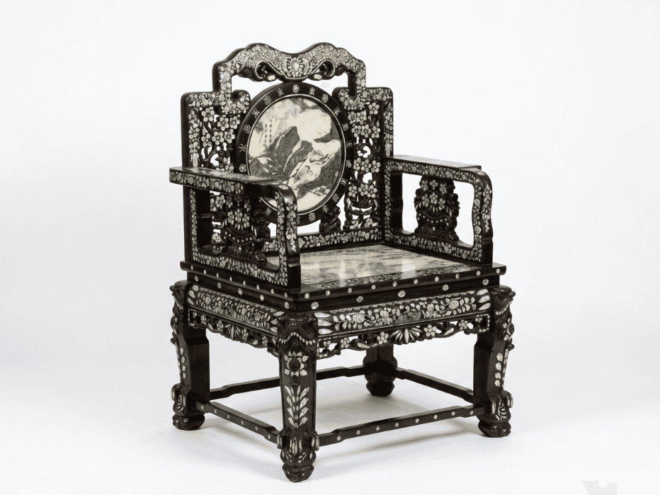 An antique East Asian armchair featuring a dark, carved hardwood frame extensively inlaid with iride… — 3D model