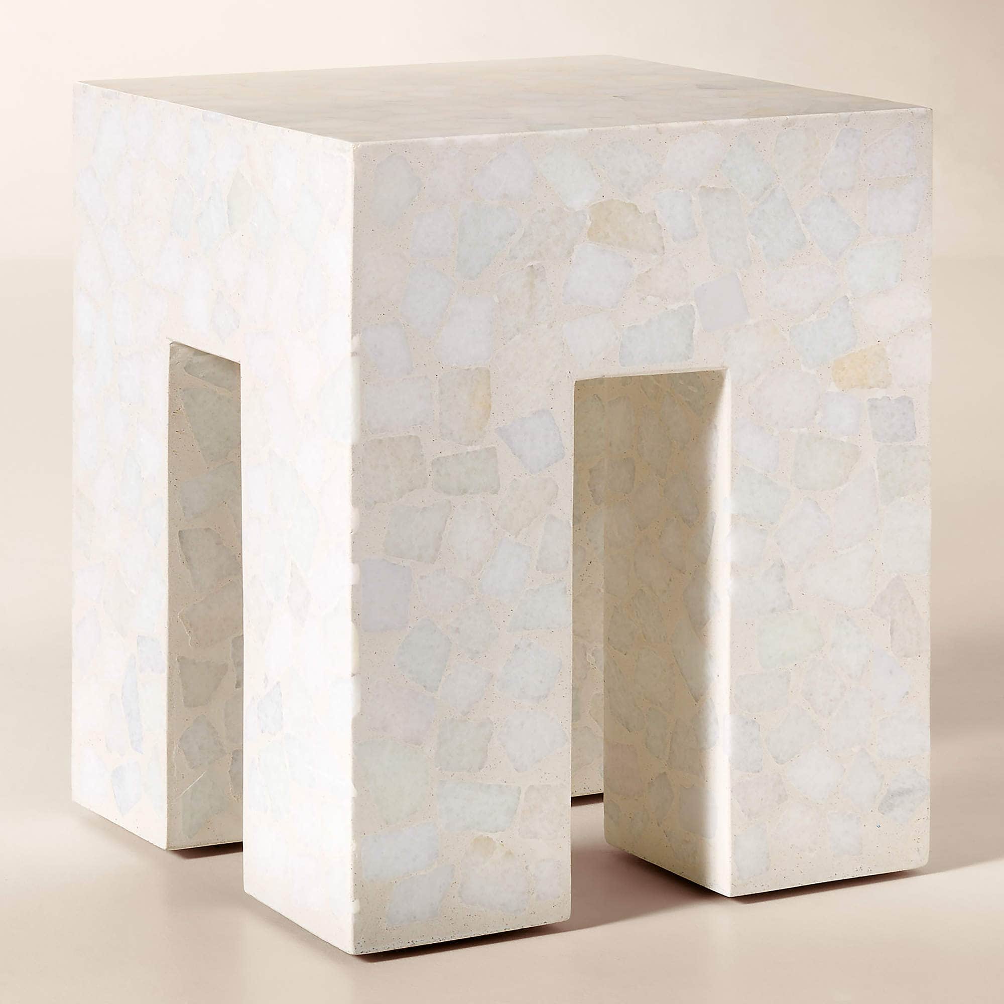 A monolithic cube-shaped side table crafted from light-toned terrazzo. The table features a solid to… — 3D model