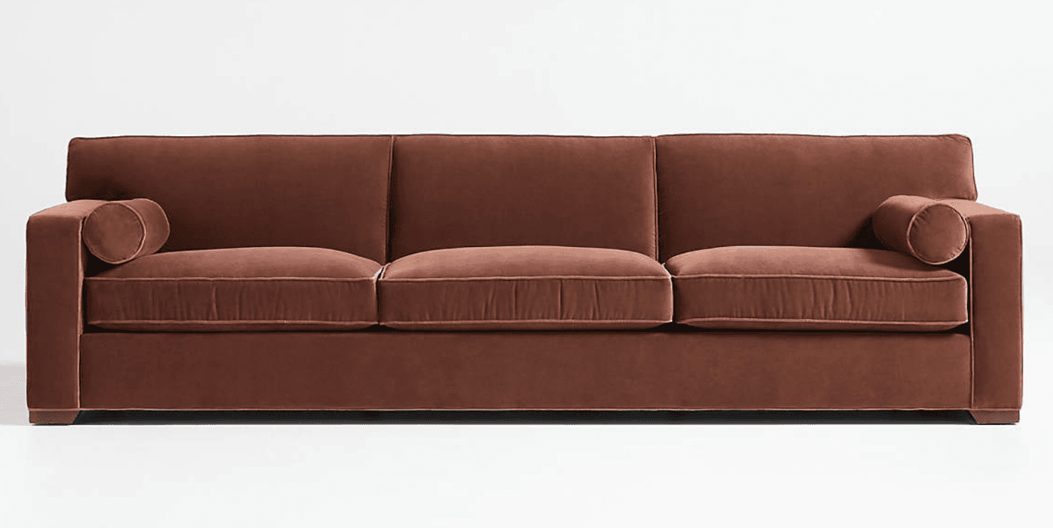 A contemporary three-seater sofa upholstered in a rich terracotta-brown velvet fabric. It features c… — 3D model