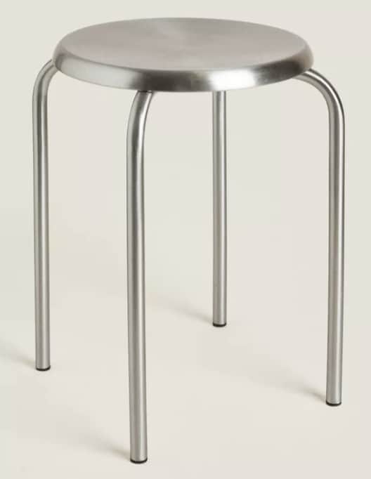 A simple, round-seated stool with four curved metal legs, featuring a minimalist and industrial desi… — 3D model