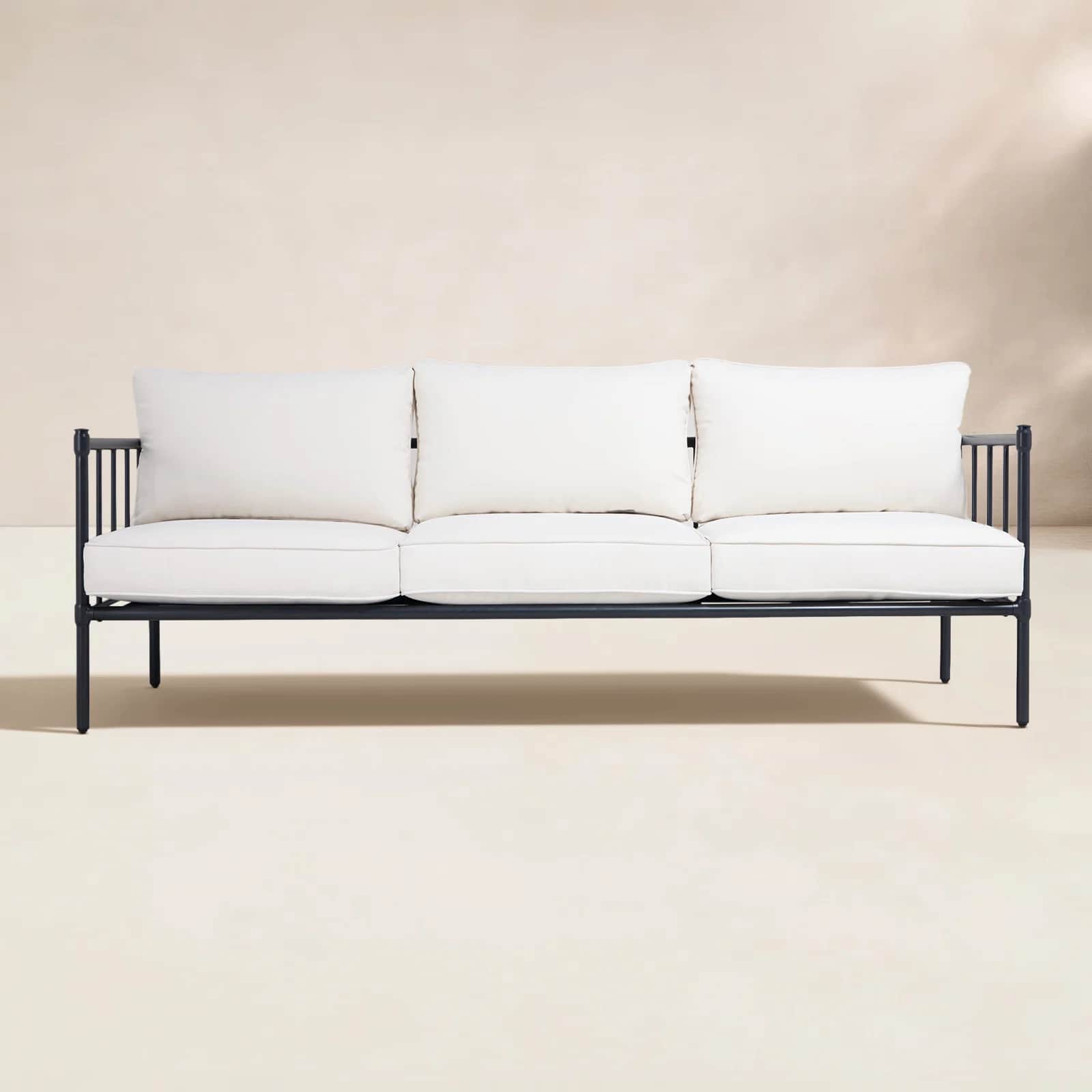 A minimalist three-seater outdoor sofa featuring a sleek black metal frame and three plush, off-whit… — 3D model