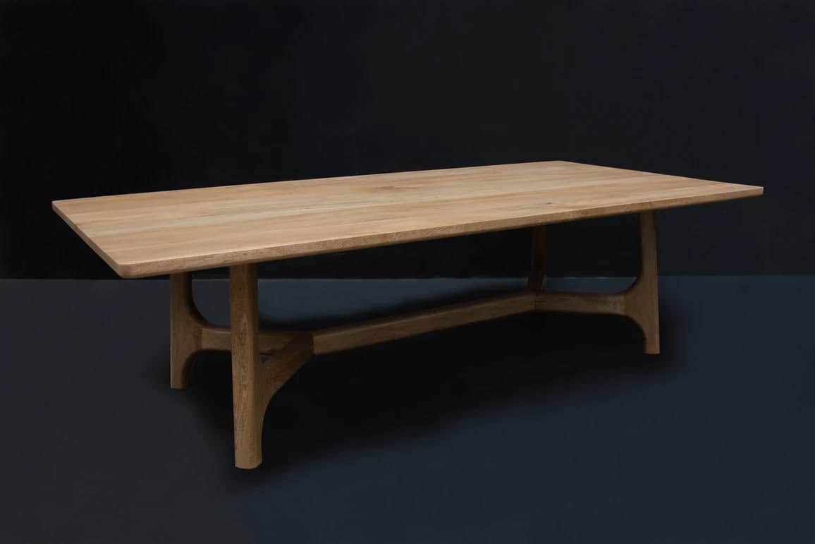 A rectangular solid wood dining table featuring a minimalist design. The tabletop has subtly rounded… — 3D model