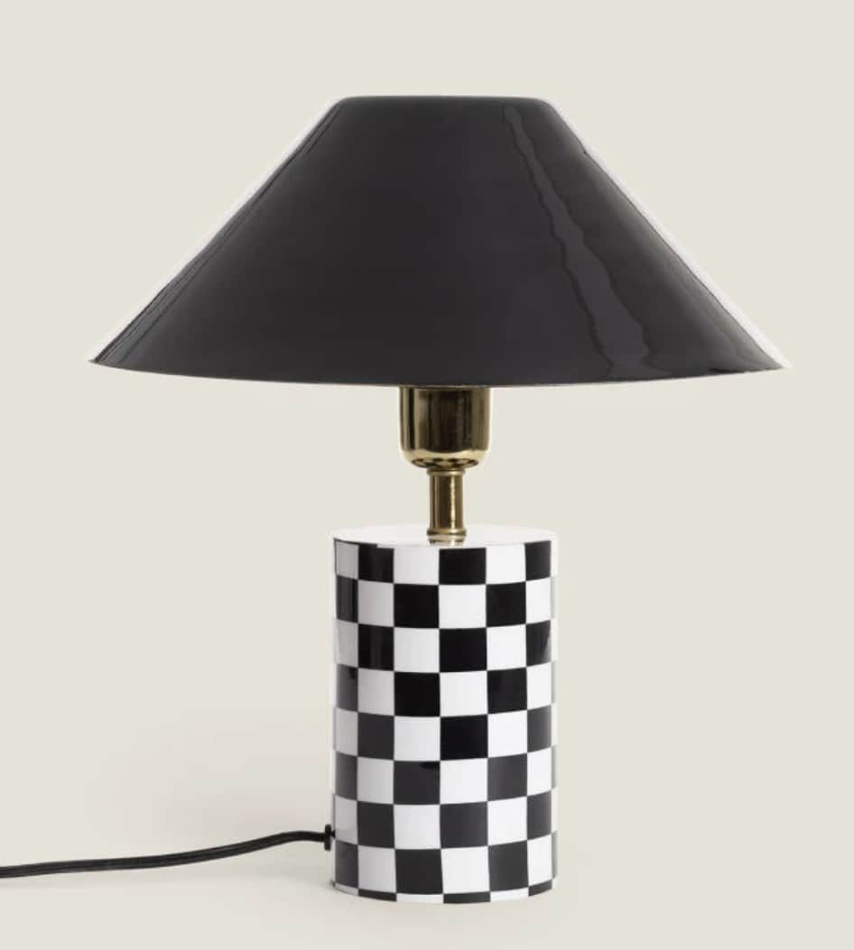 A contemporary table lamp featuring a cylindrical base adorned with a black and white checkerboard p… — 3D model