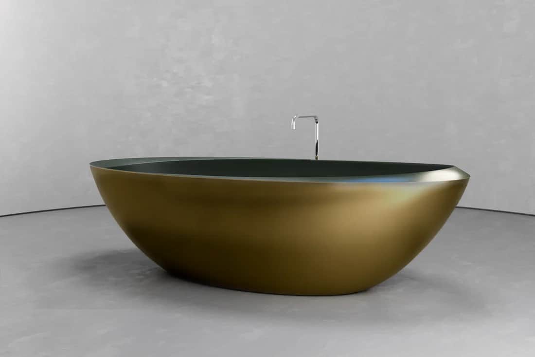 A freestanding bathtub with an oval, tapered shape. The exterior is a metallic, brushed gold finish,… — 3D model