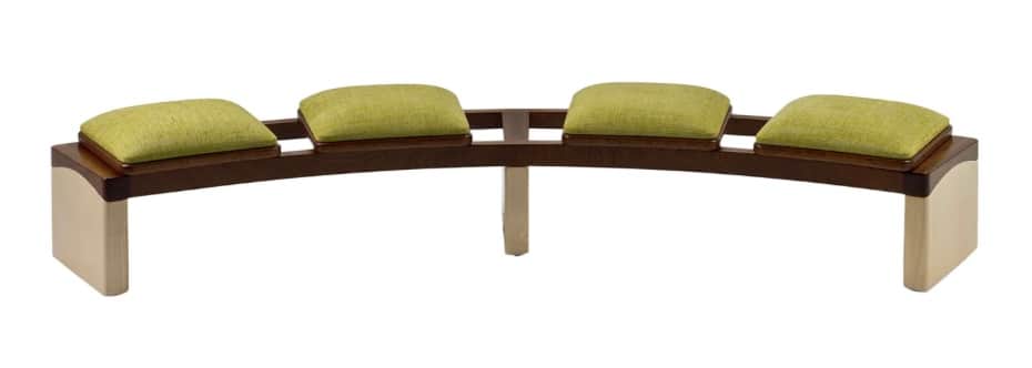 A contemporary, curved bench with four separate cushioned seats. The bench features a dark wood fram… — 3D model