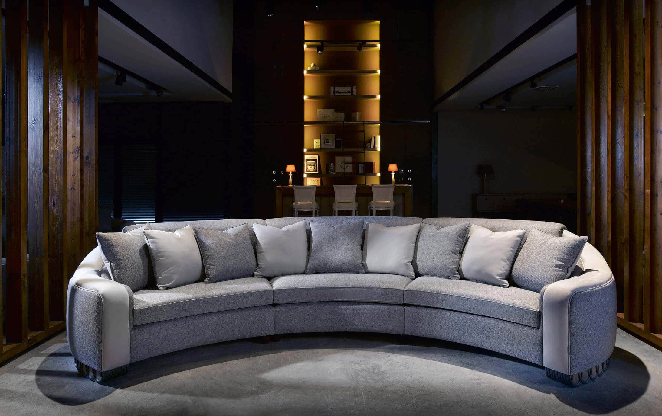 A large, contemporary curved sectional sofa upholstered in a light grey textured fabric. It features… — 3D model