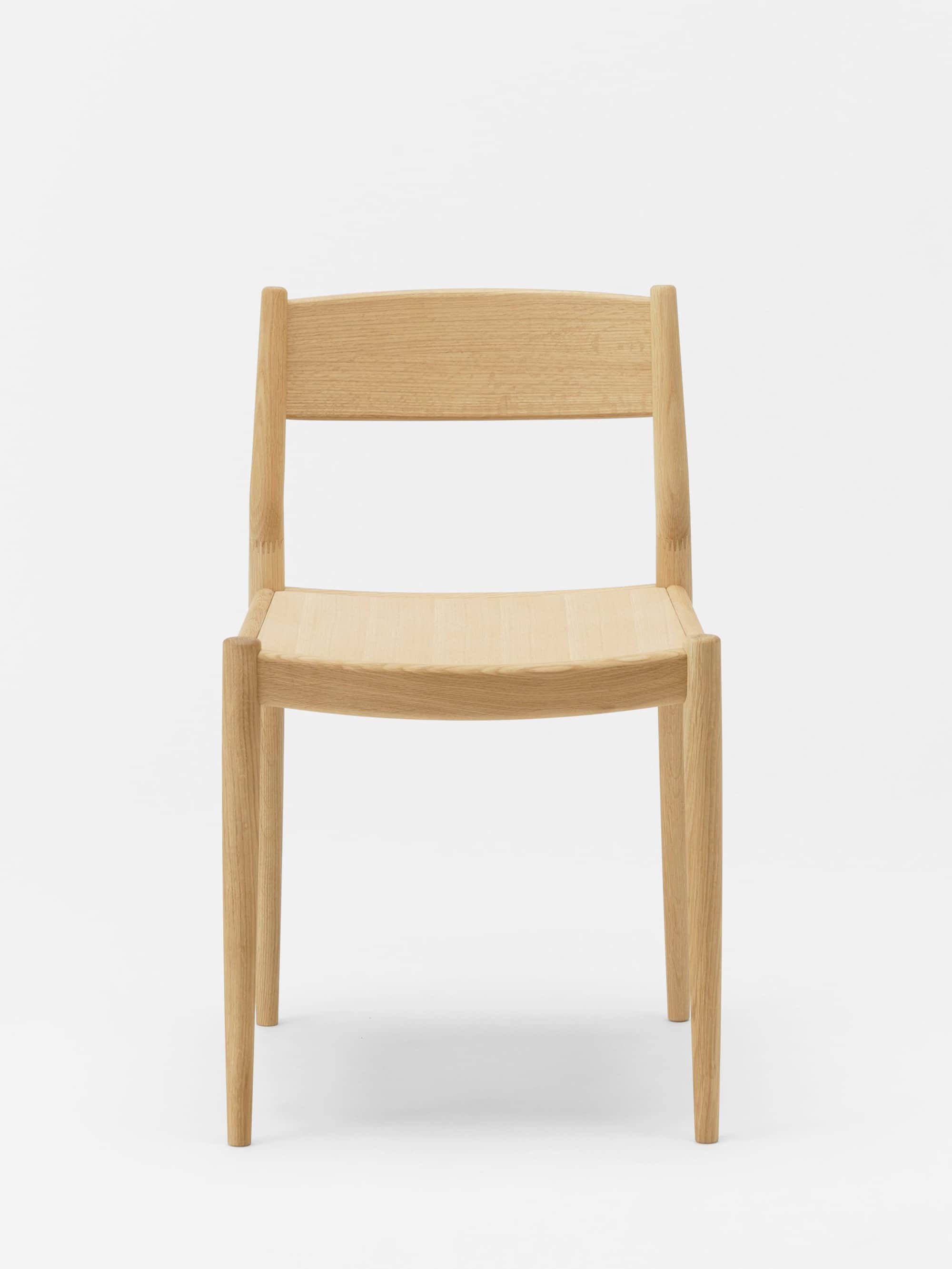 A minimalist wooden chair with a gently curved backrest and seat. The chair features four tapered le… — 3D model