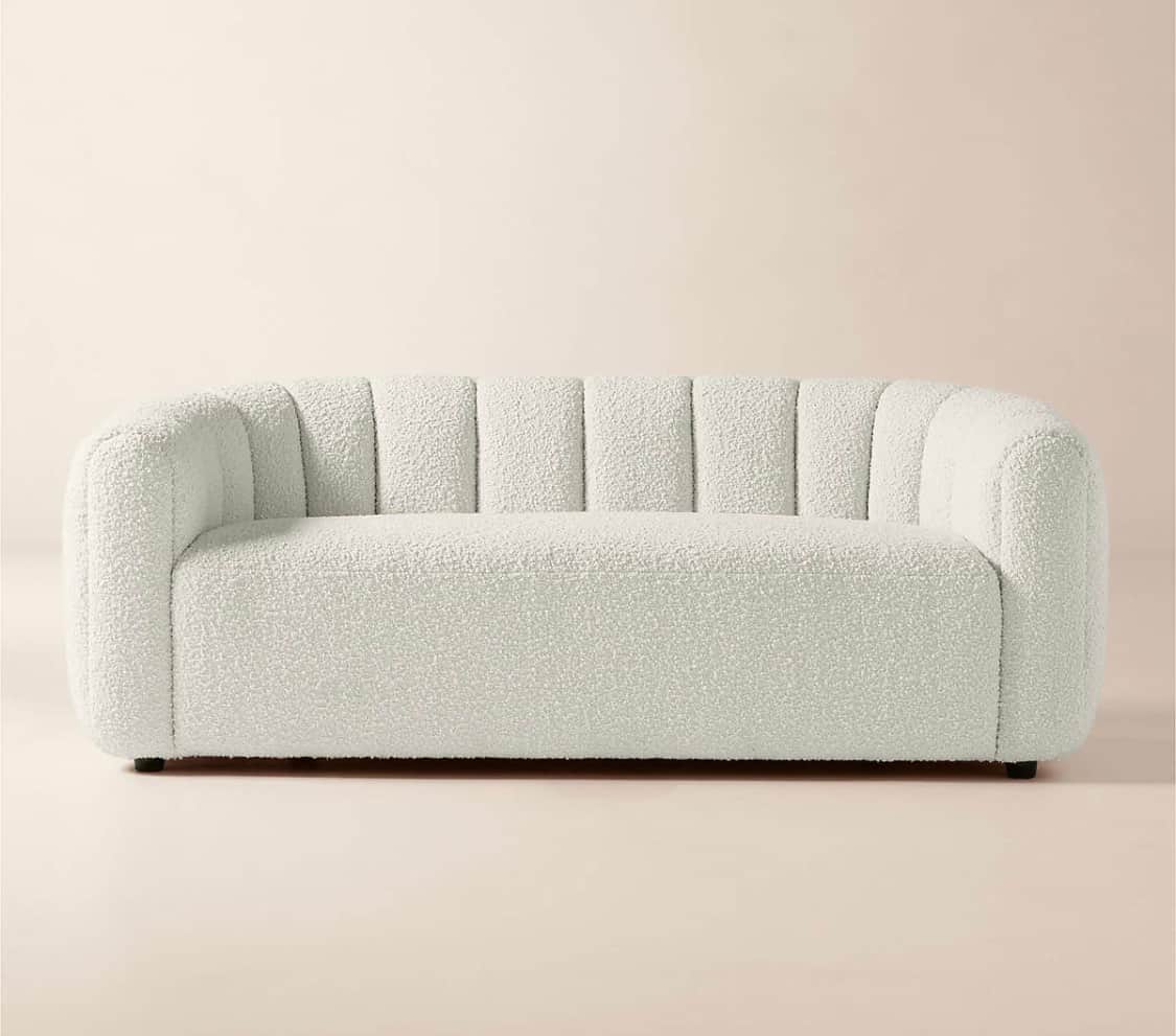 A contemporary three-seater sofa featuring a distinctive channel-tufted design on its backrest and i… — 3D model