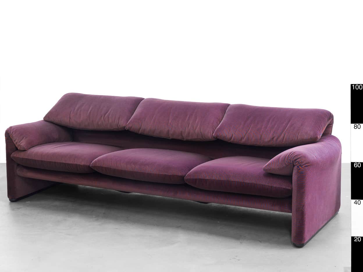 A three-seater sofa with plump, oversized cushions and a low-profile base. The upholstery features a… — 3D model