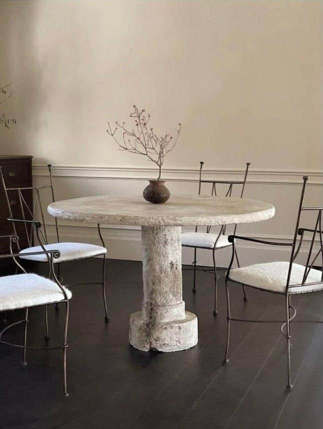 A round, pedestal table with a rough, textured surface. The pedestal has a columnar design with a de… — 3D model