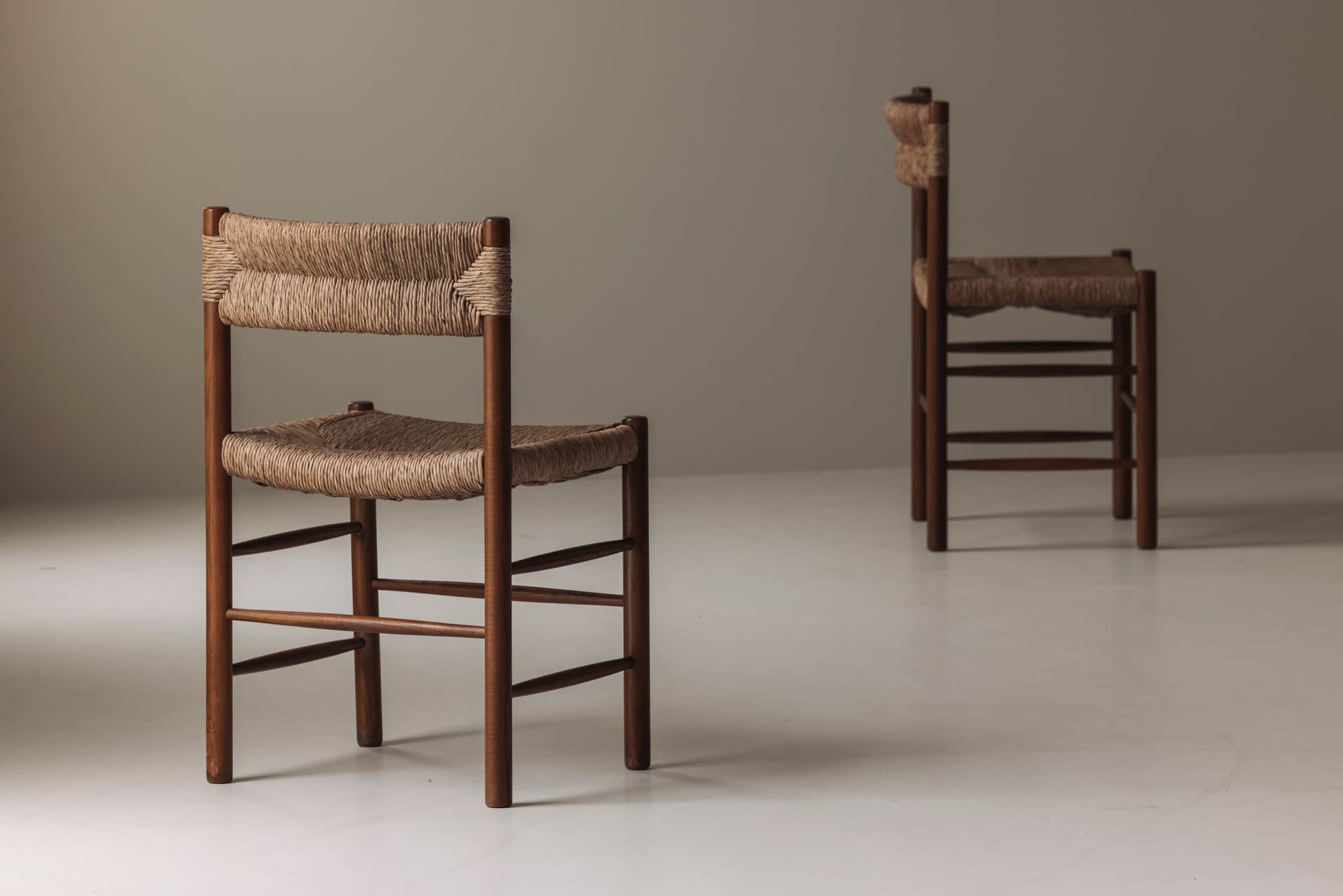 A pair of armless chairs featuring a sturdy wooden frame and intricately woven cord for both the sea… — 3D model