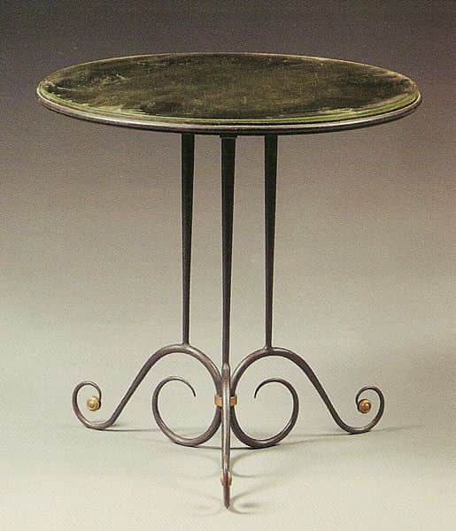 A small, round side table with a dark green glass top and a wrought iron base. The base features thr… — 3D model