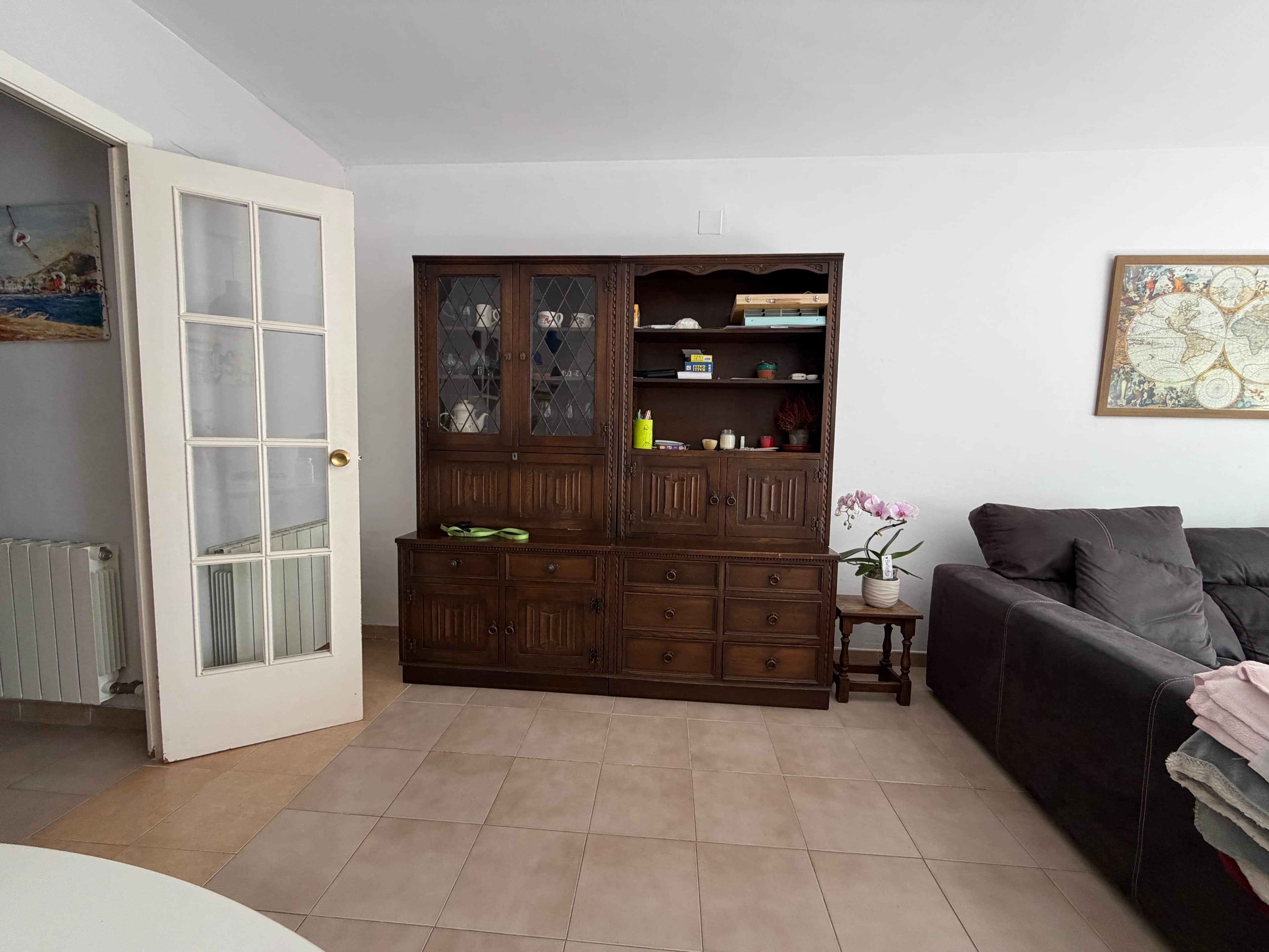 A traditional dark wood china cabinet, consisting of a hutch top with two sets of glass-paned double… — 3D model