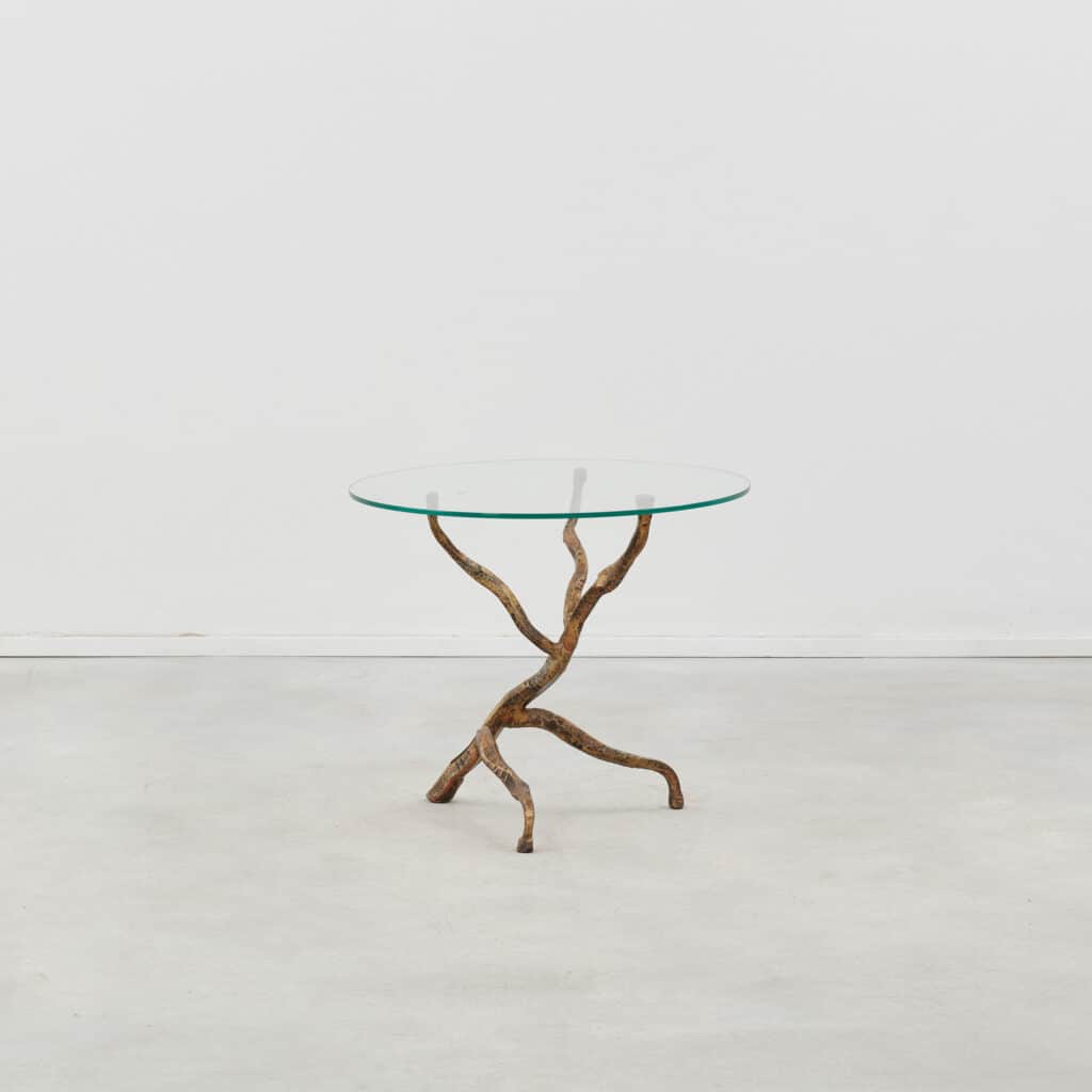 A round glass-topped table with a sculptural base resembling intertwined branches or roots, finished… — 3D model