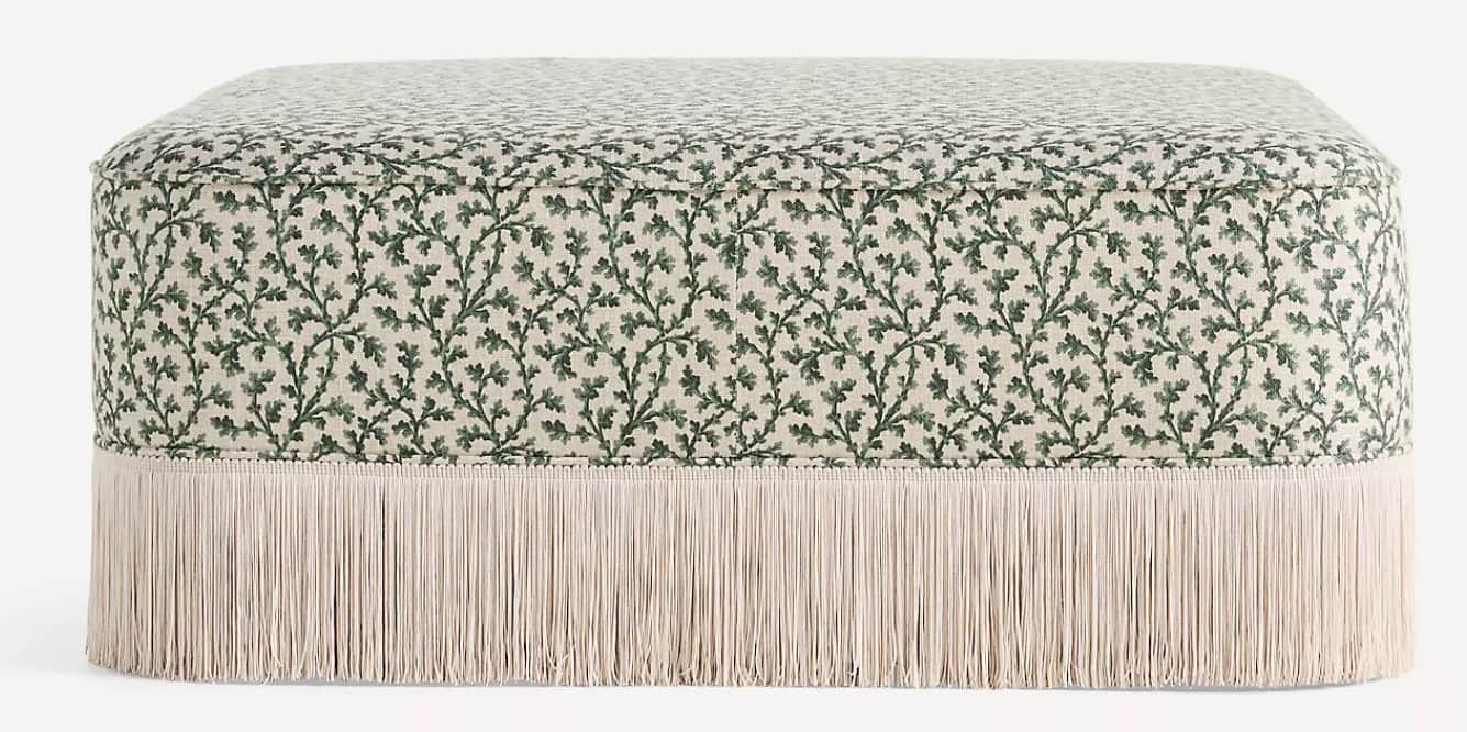 A rectangular ottoman with a padded top, upholstered in a fabric featuring a repeating pattern of gr… — 3D model