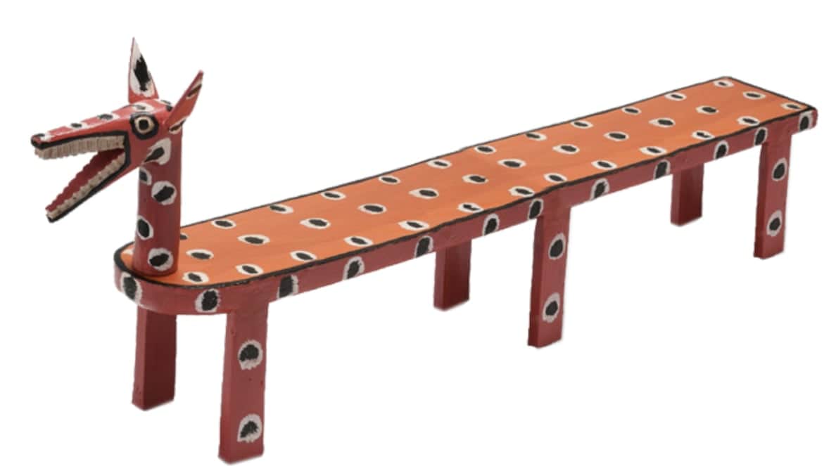 A long, narrow wooden bench featuring a stylized animal head, possibly a fox or dog, at one end. The… — 3D model