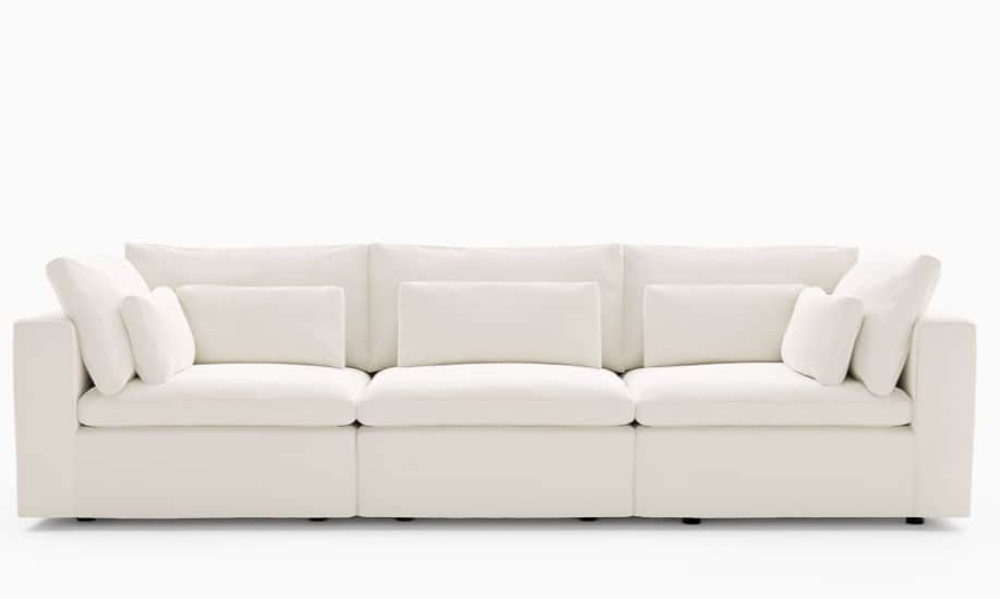 A modern, plush, off-white three-piece modular sectional sofa with deep seats and numerous soft cush… — 3D model