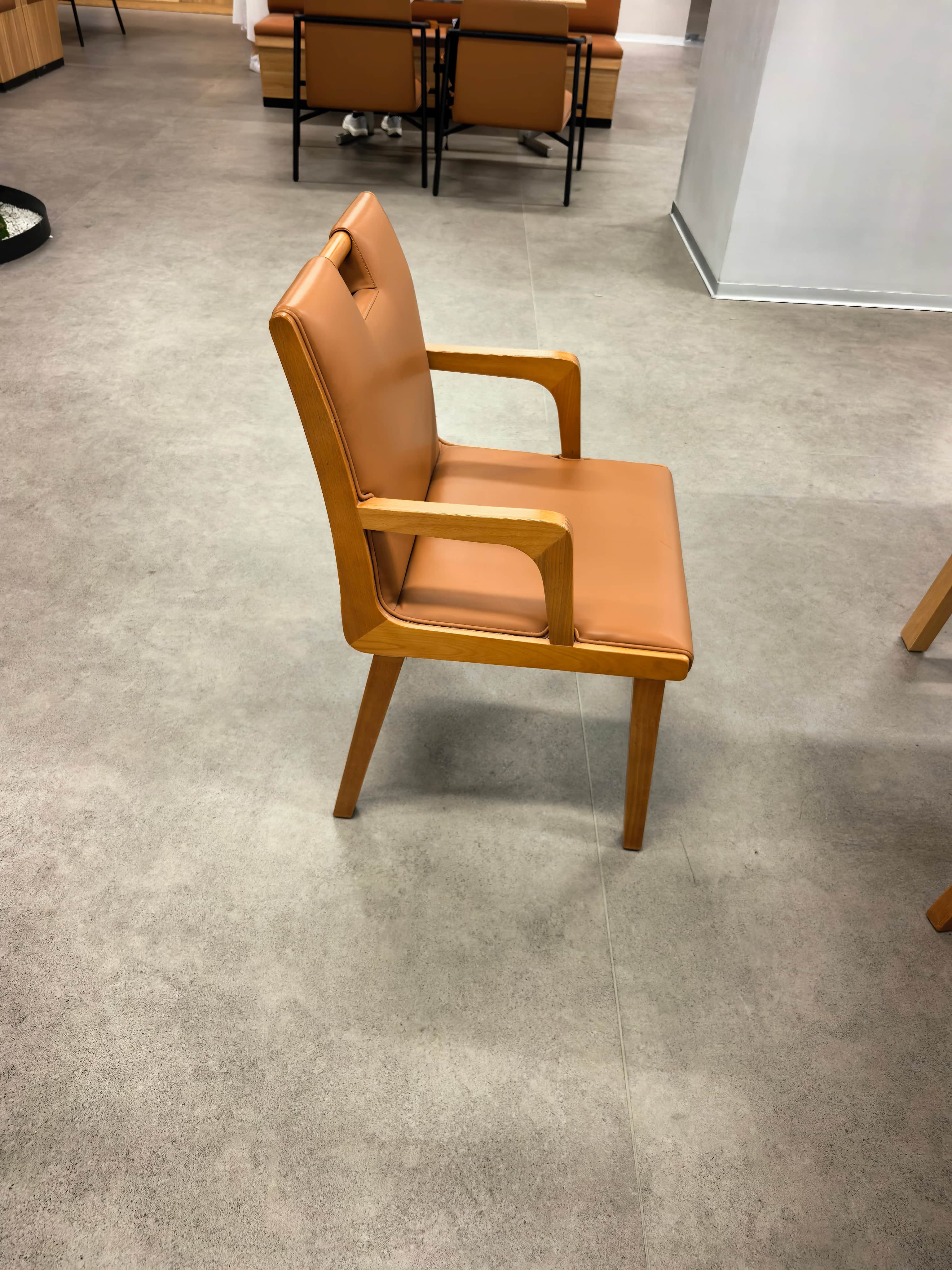 A contemporary armchair featuring a wooden frame and tan-colored upholstery on the seat and backrest… — 3D model