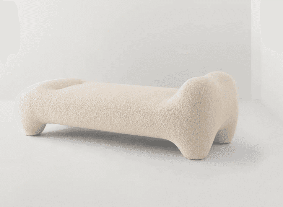 A long, low-profile, sculptural bench upholstered in a light, textured fabric, likely bouclé. It fea… — 3D model