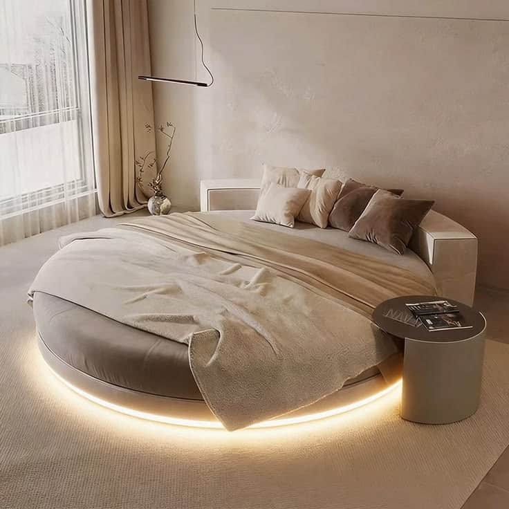 A modern, round bed with a large, padded headboard that curves around the back. It features integrat… — 3D model