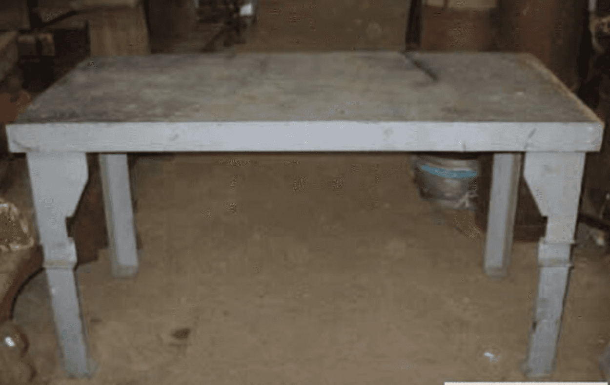 A rectangular dining table constructed from a solid, grey, textured material resembling concrete or… — 3D model