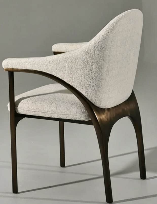 A modern armchair featuring a curved upholstered back and seat, supported by a dark, open wood frame… — 3D model