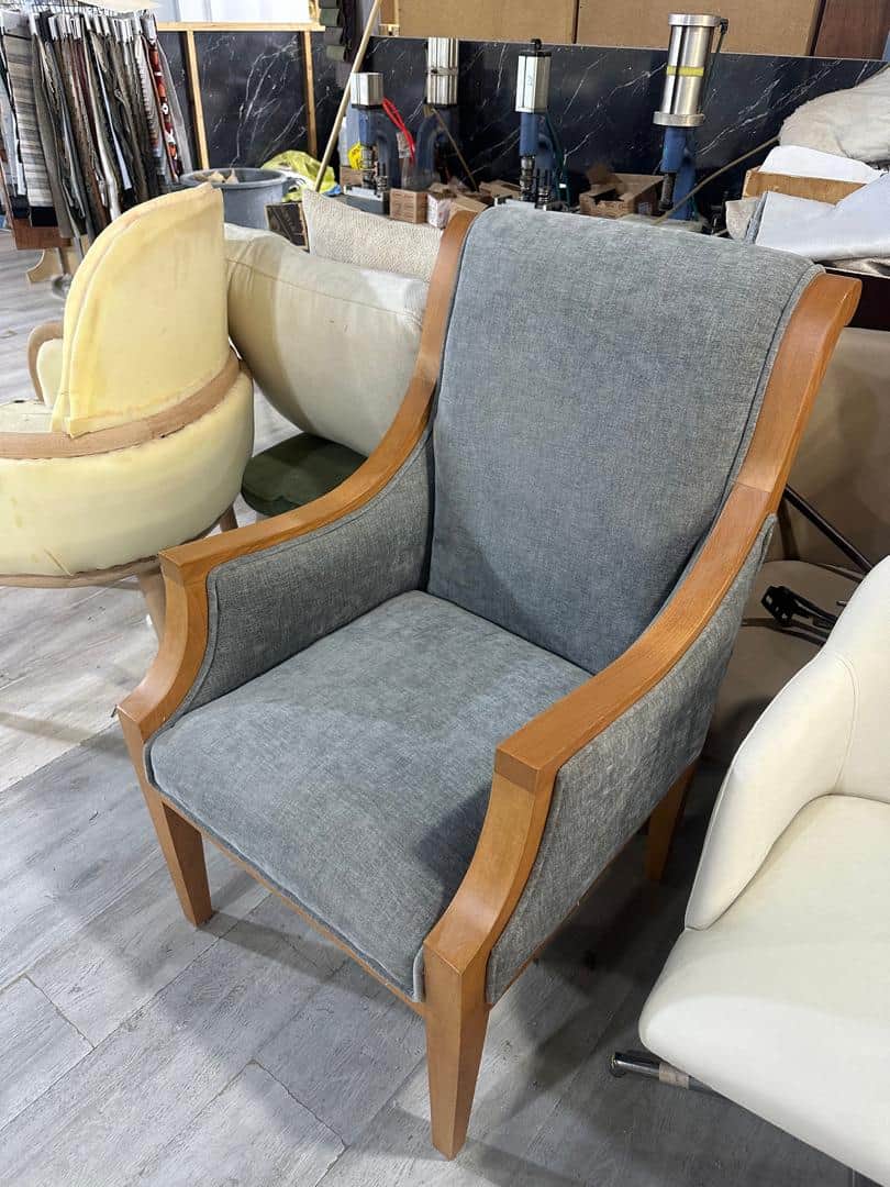 A transitional style armchair featuring a light-toned wooden frame with visible, curved armrests and… — 3D model