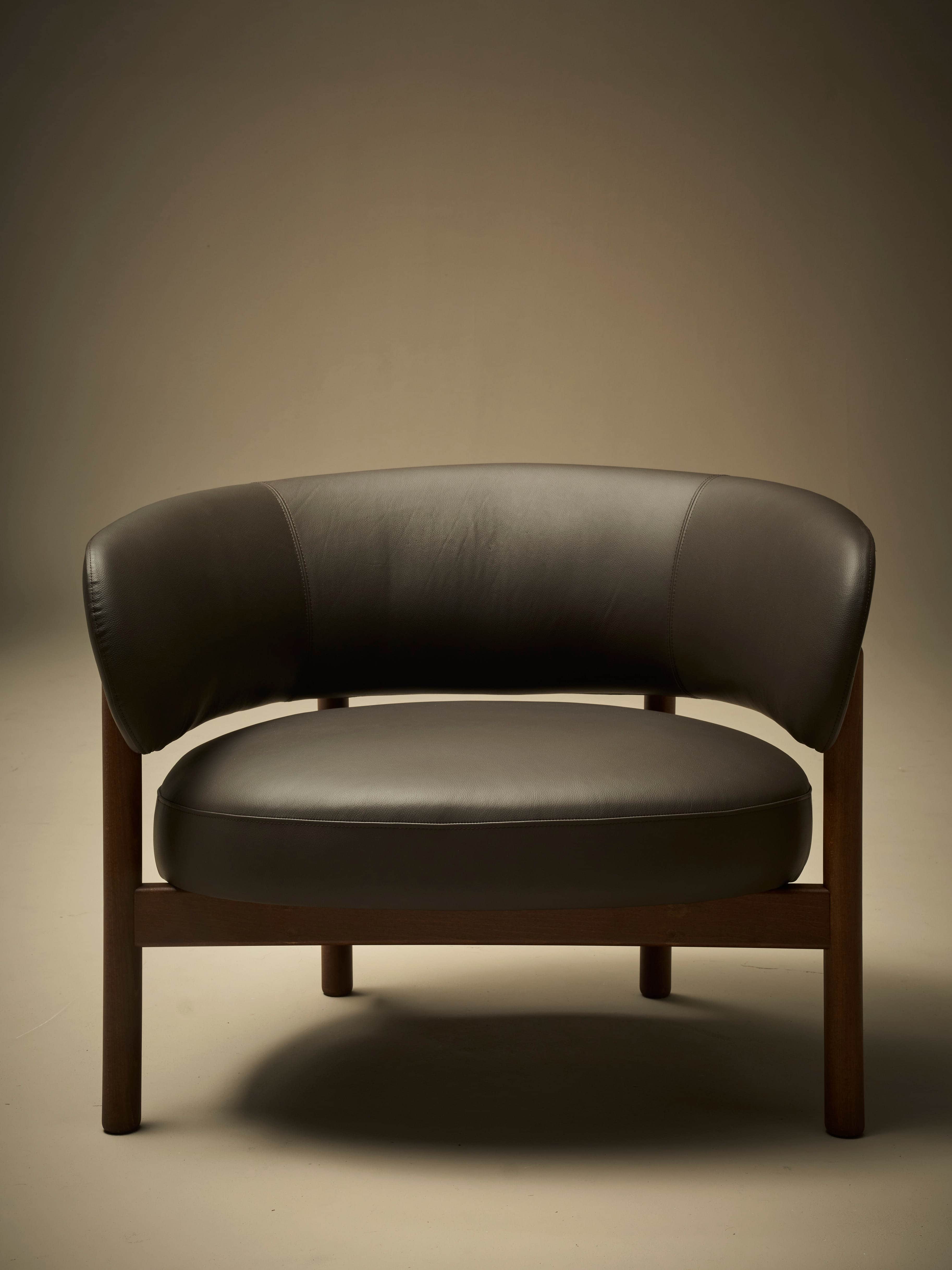 A low-profile armchair with a dark brown leather upholstered seat and curved backrest. The frame and… — 3D model