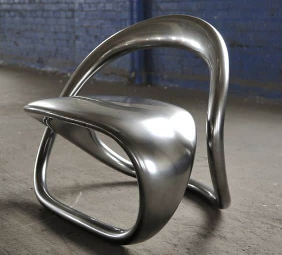 A modern, sculptural chair with a fluid, continuous form. It appears to be made from a single piece… — 3D model