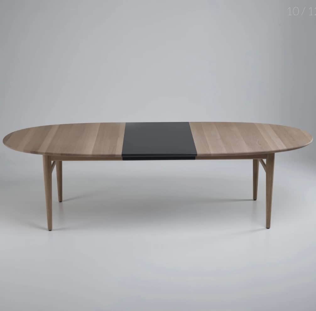 An oval dining table with a light wood finish and a contrasting dark inlay in the center. The table… — free BLEND 3D model