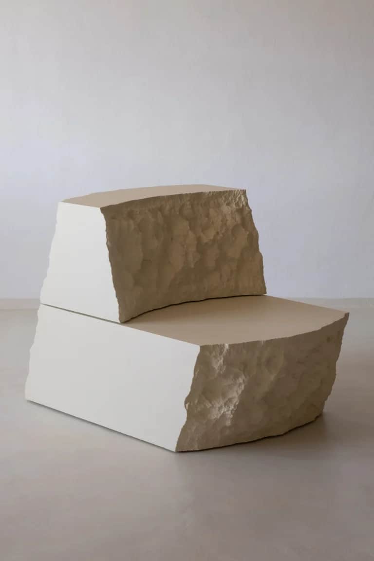 A sculptural lounge chair composed of two block-like pieces, resembling carved stone, in an off-whit… — 3D model