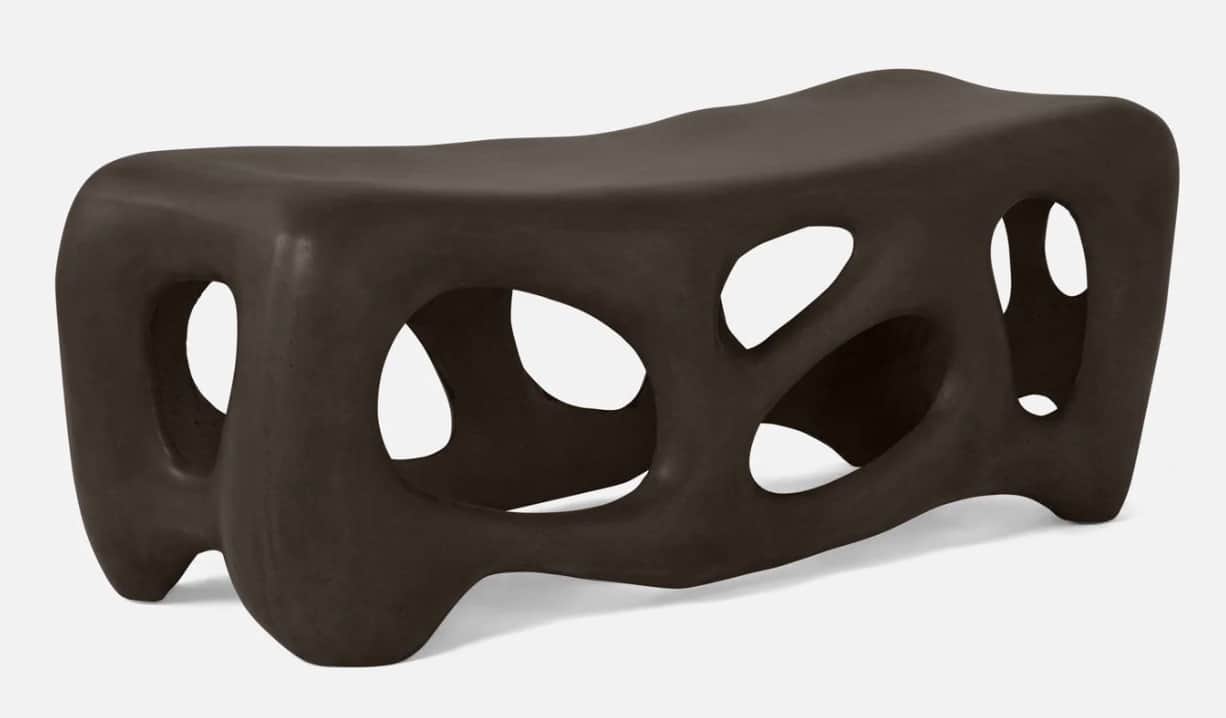 A modern, abstract bench with a dark brown, matte finish. The design features organic, irregular ope… — 3D model