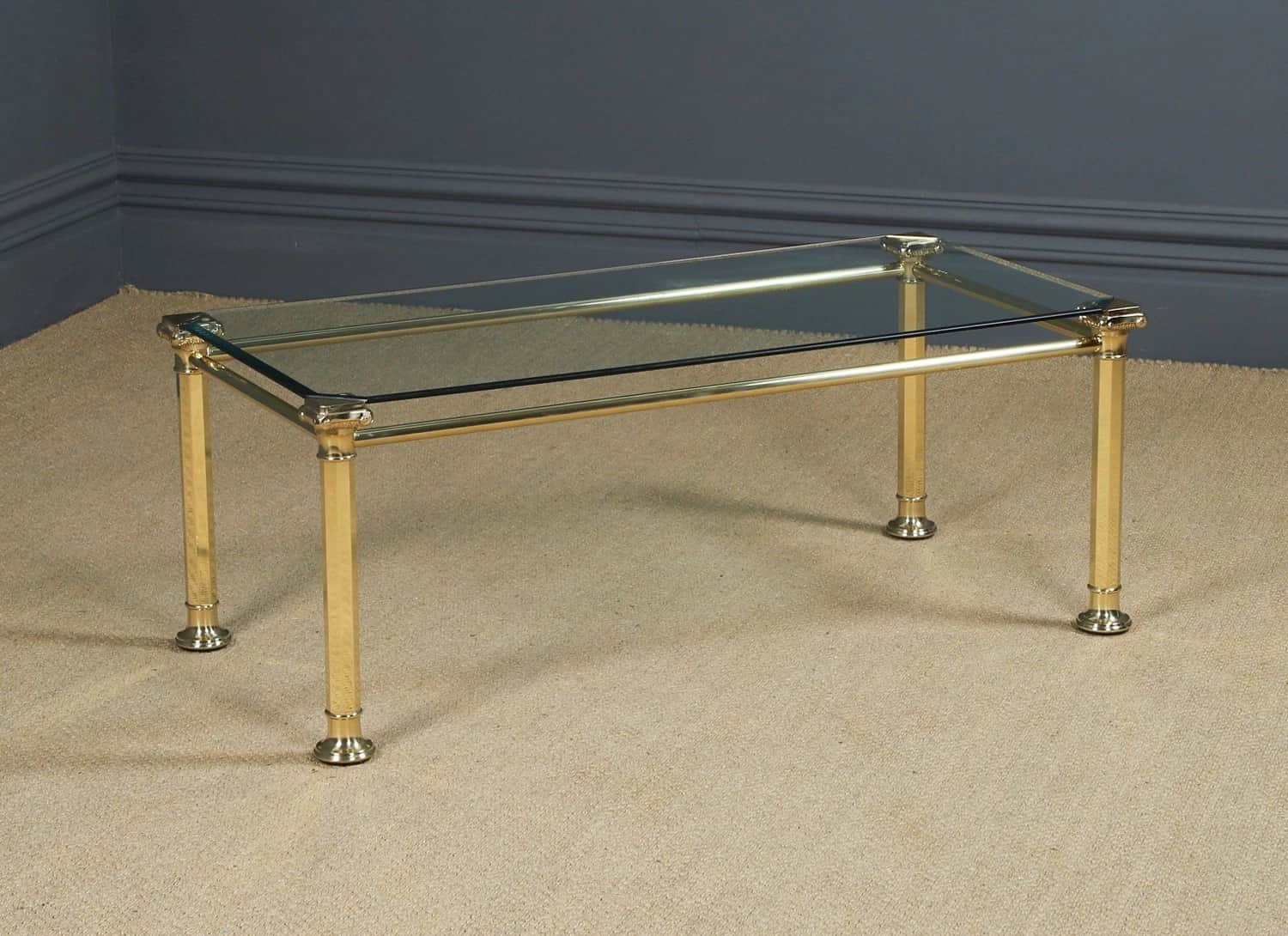 A rectangular coffee table featuring a polished brass tubular frame and a smoked glass top. The desi… — 3D model