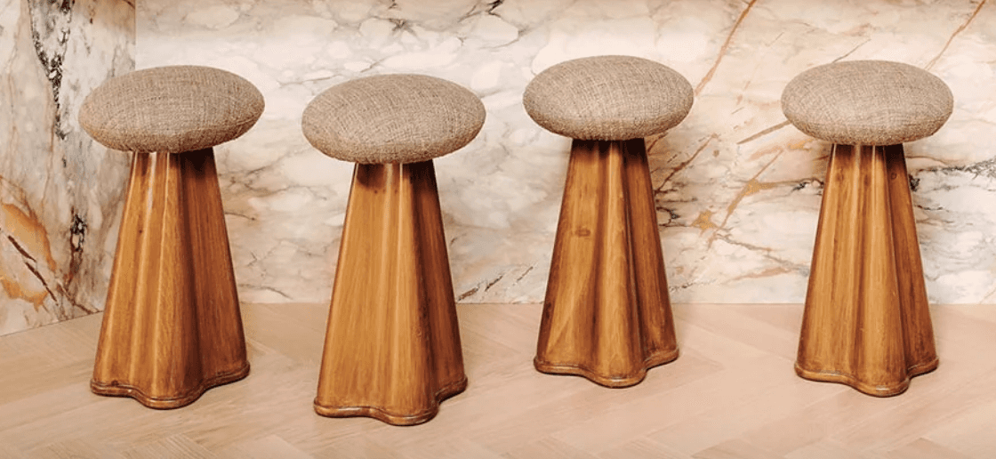A stool with a round upholstered seat and a flared wooden base. The base has a textured wood grain p… — 3D model