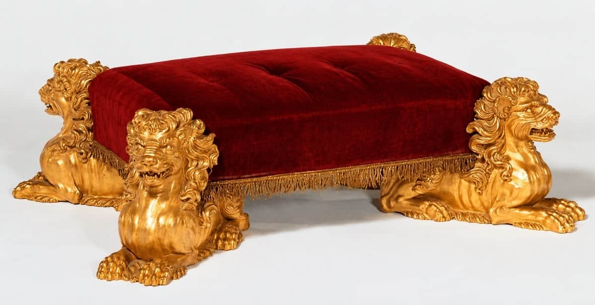 A rectangular ottoman featuring a deeply button-tufted red velvet upholstered top, supported by four… — 3D model